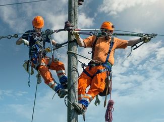 [Translate to Italienisch (IT):] Installatori di linee elettriche al lavoro